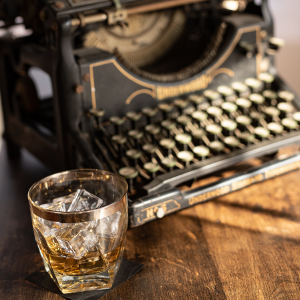 vintage typewriter and glass of whiskey