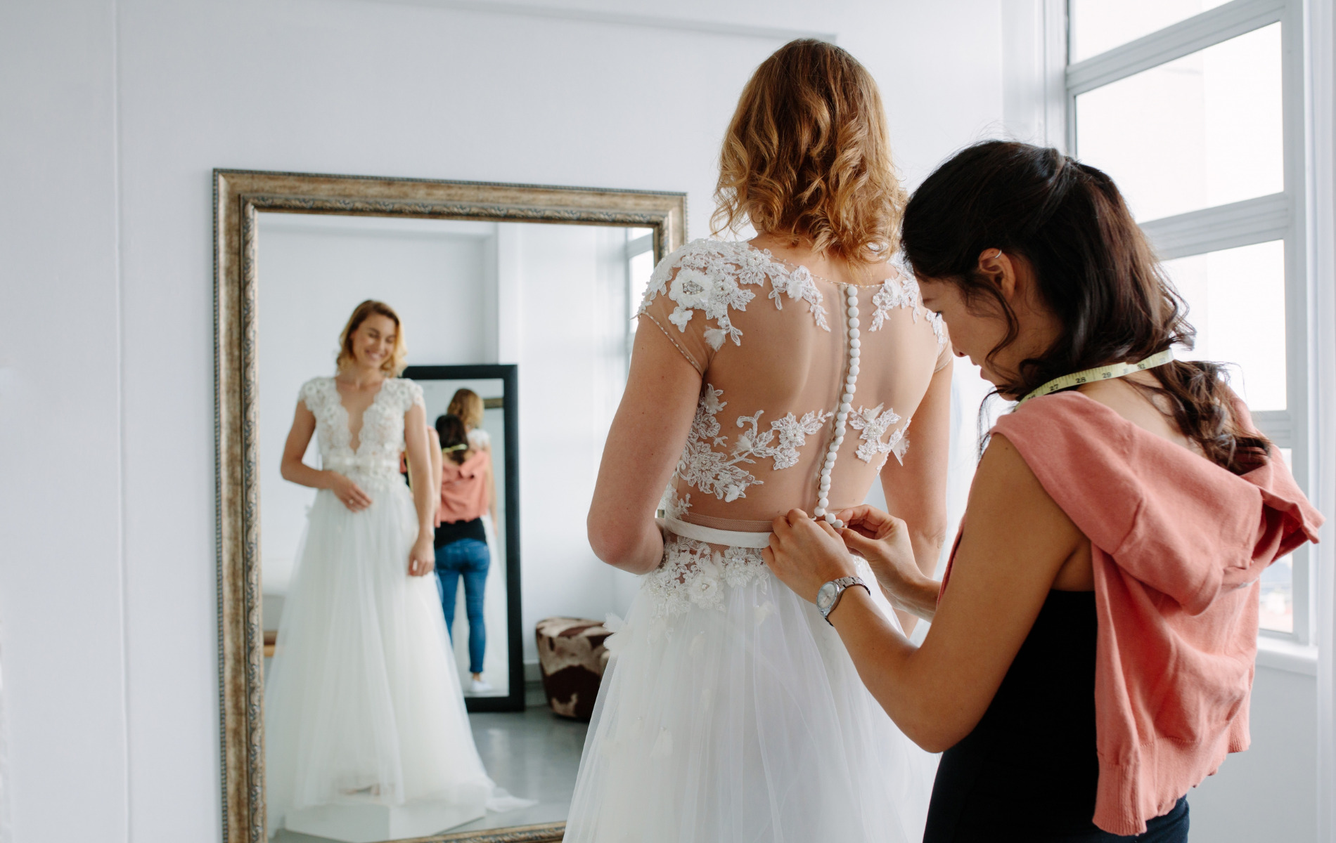 woman getting fitted for bridal dresses by bridal store stylist